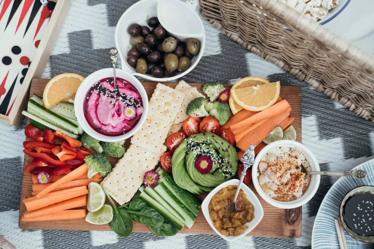 A table of vegan foods, salads and fruits from a top down perspective